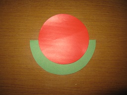 緑の半円画用紙の上に、赤の丸折り紙を図のように貼ります